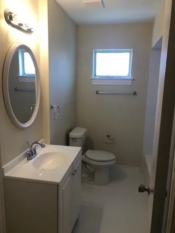 a bathroom with a toilet sink and mirror