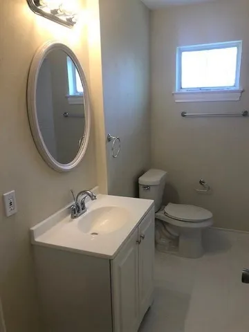 a bathroom with a toilet sink and mirror