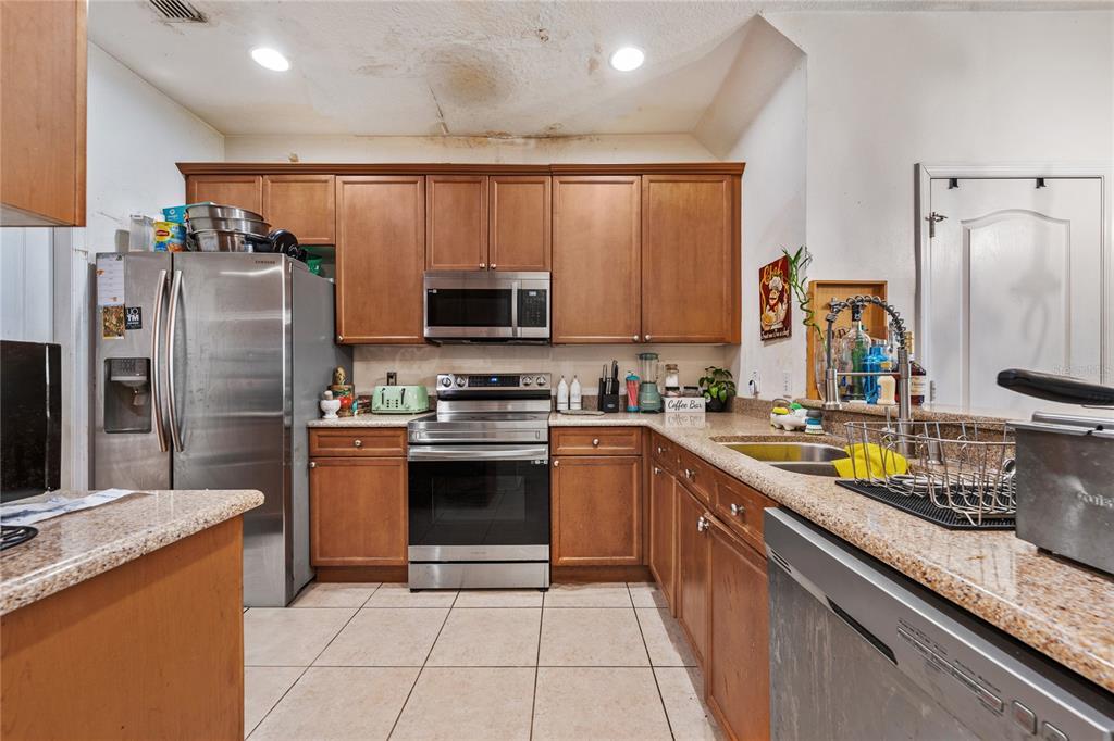 6039 Strada Isle Way Orlando, FL 32835 - Photo 3 of 24 a kitchen with stainless steel appliances a refrigerator sink and microwave
