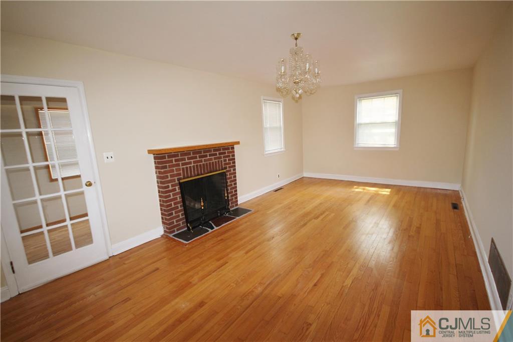 55 Milltown Road East Brunswick, NJ 08816 - Photo 2 of 18 a view of an empty room with wooden floor fireplace and a window