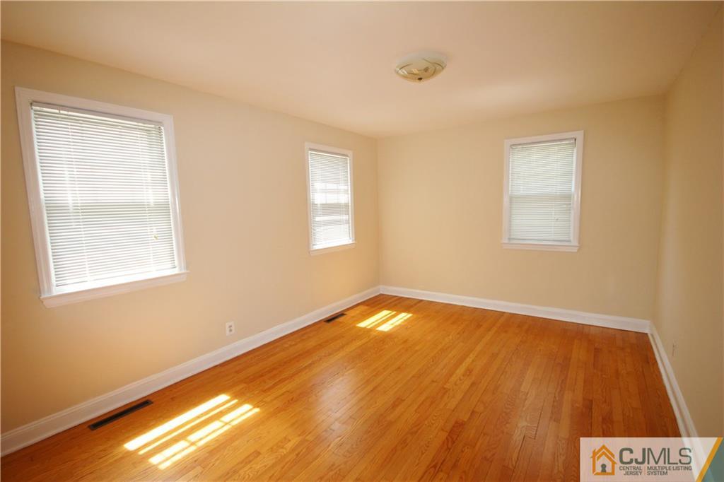 55 Milltown Road East Brunswick, NJ 08816 - Photo 7 of 18 a view of an empty room with wooden floor and a window