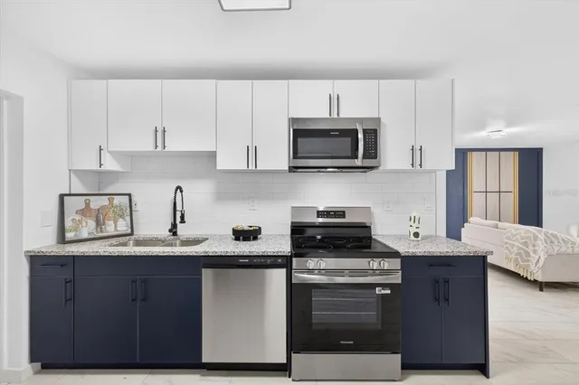 a kitchen with granite countertop a sink and steel appliances