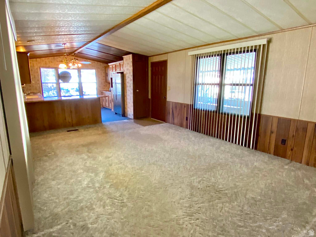 1111 North 2000 West, Unit 147 Ogden, UT 84404 - Photo 7 of 12 Spacious room featuring light-toned carpeting and wood-paneled wainscoting