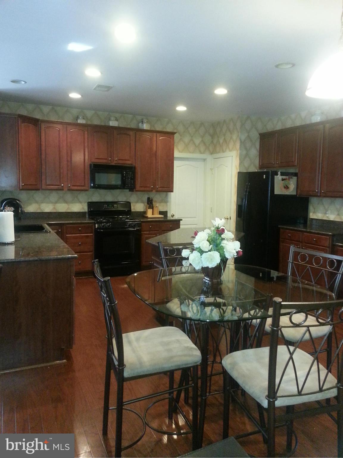 2000 Medinah Ridge Road Accokeek, MD 20607 - Photo 6 of 20 a kitchen with a dining table chairs and refrigerator