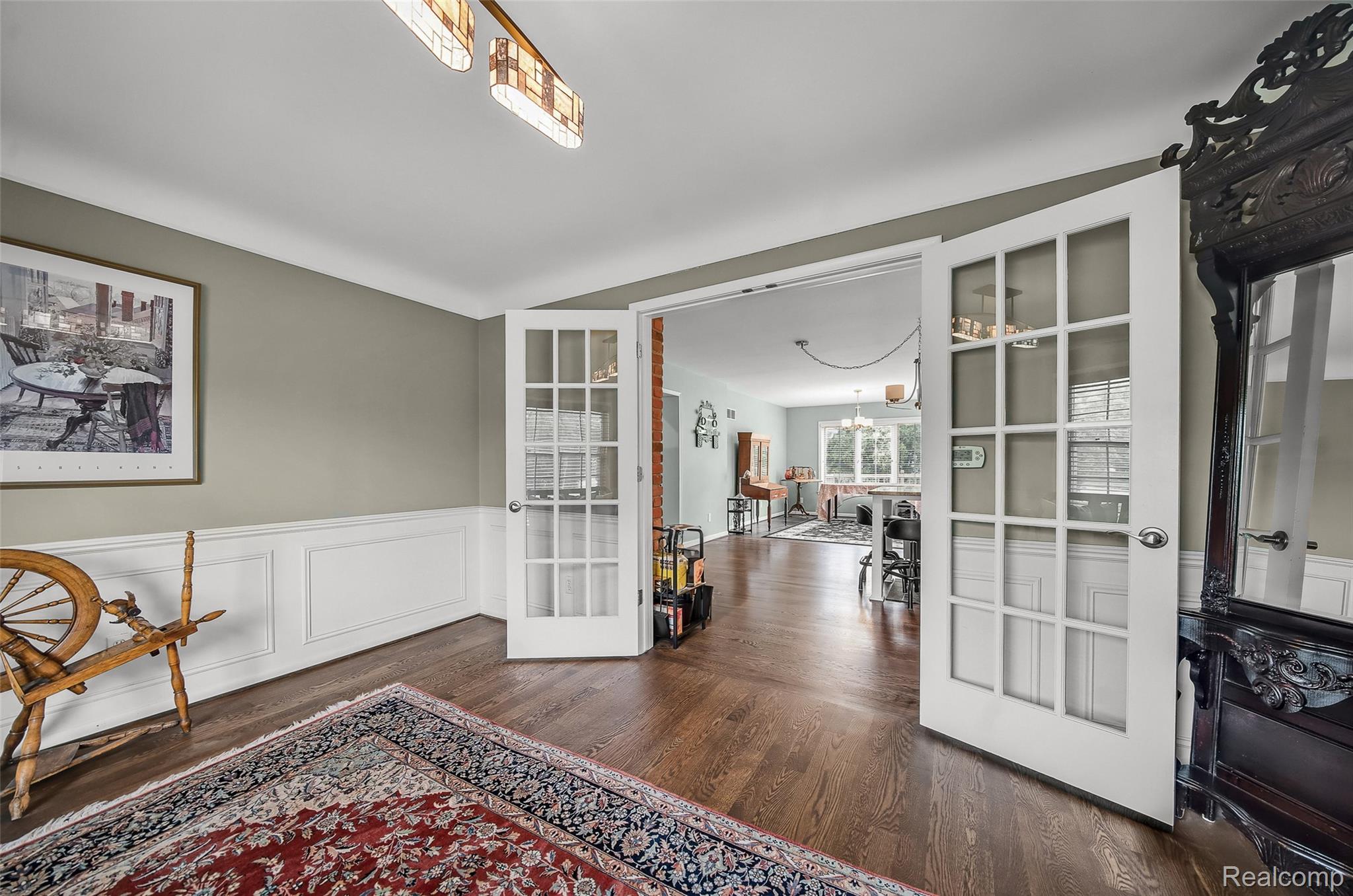 100 Overhill Road Bloomfield Hills, MI 48301 - Photo 13 of 55 Sitting room with a wainscoted wall, a decorative wall, dark wood-type flooring, french doors, and a chandelier