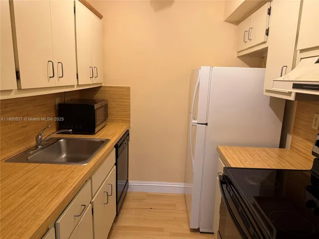 a kitchen with a refrigerator and a sink