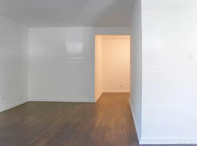 a view of a small space with wooden floor and a window