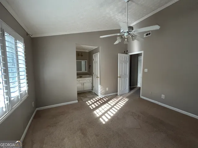 a view of empty room with window and ceiling fan