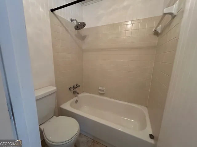 a white toilet sitting next to a bath tub