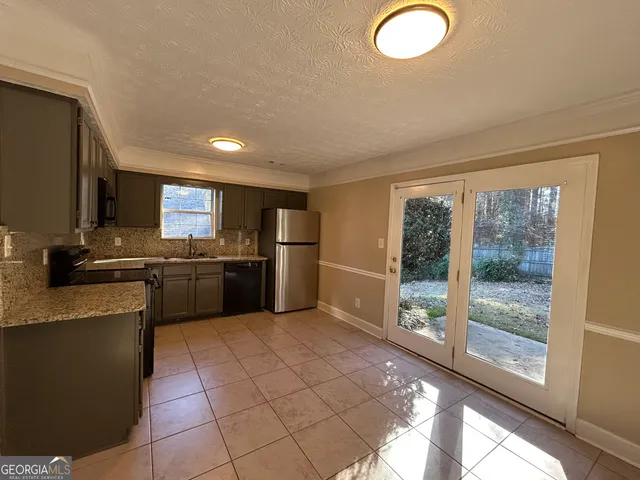 a kitchen with stainless steel appliances granite countertop a stove a sink and a refrigerator