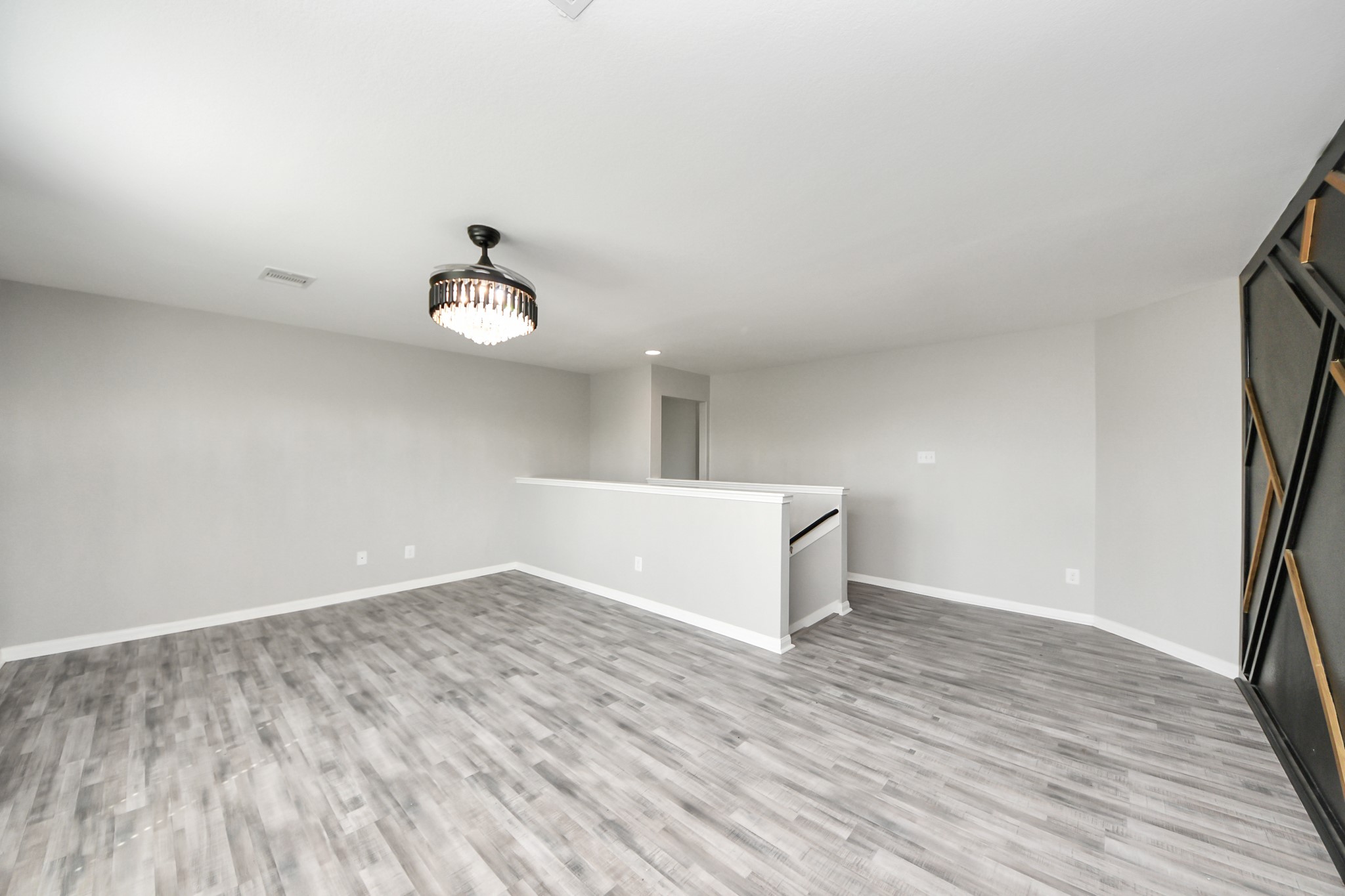 6931 Primrose Road Baytown, TX 77521 - Photo 30 of 50 Upstairs game room / flex room with wood-look flooring, neutral paint, and an open layout ideal for entertaining, a media space, home office, or playroom.