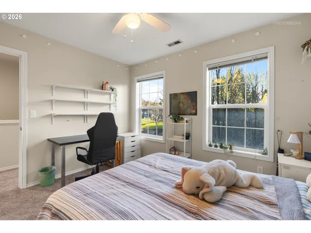 a bedroom with a bed and a large window