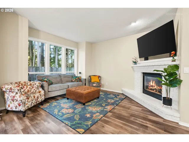 a living room with furniture a flat screen tv and a fireplace