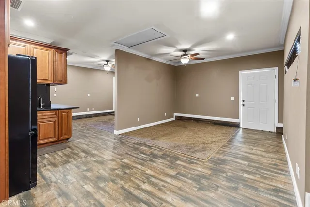 an empty room with a ceiling fan and a rug