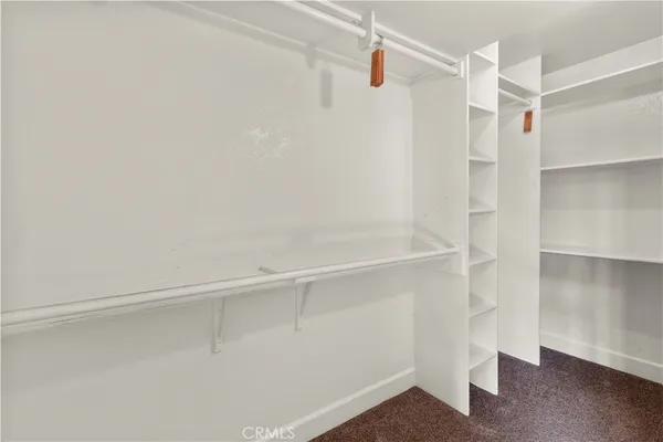 a view of walk in closet with empty racks