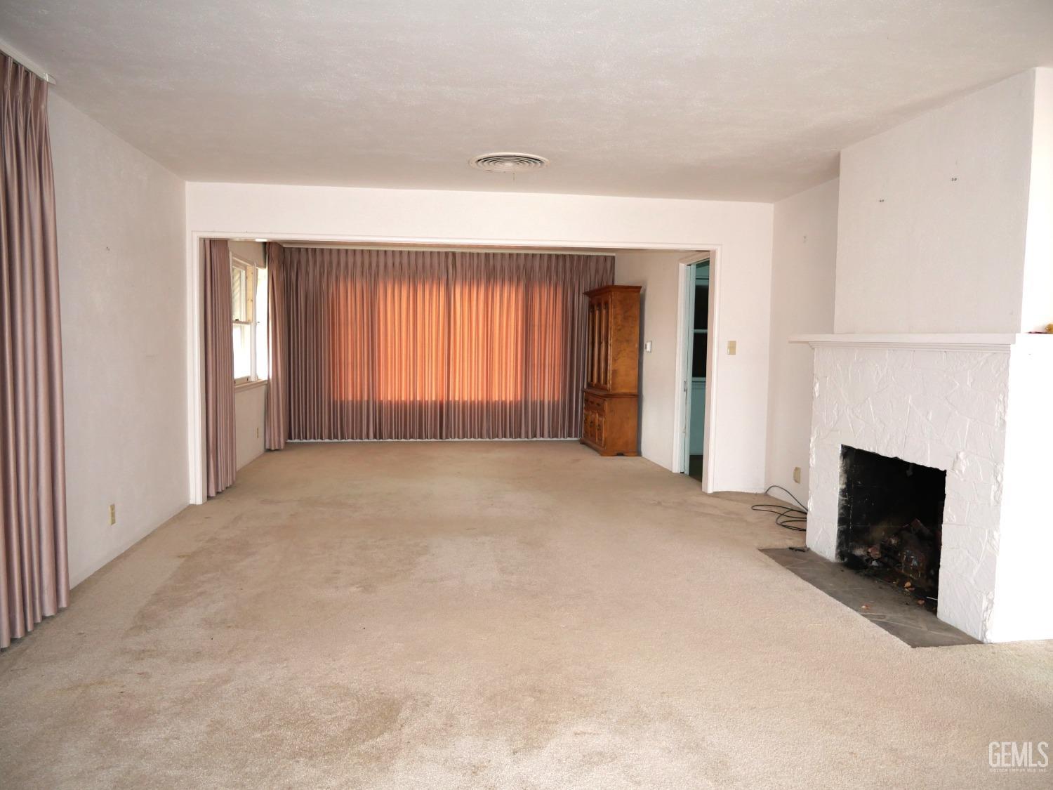 Undisclosed Address Delano, CA 93215 - Photo 2 of 7 an empty room with windows and fireplace