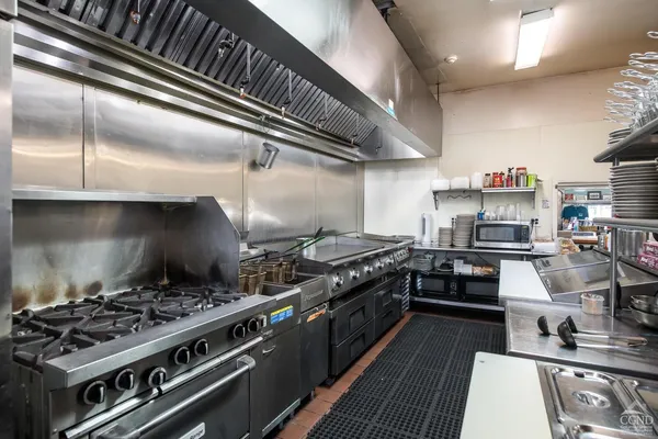 a kitchen with a stove and a wooden floors