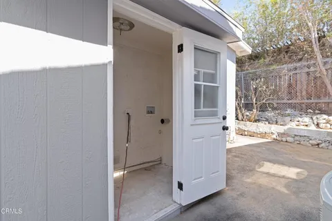 a view of a house with a door and wooden fence