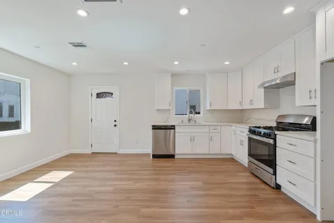 a large kitchen with stainless steel appliances granite countertop a stove and a sink