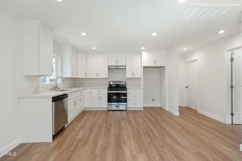 a kitchen with wooden floors and refrigerator