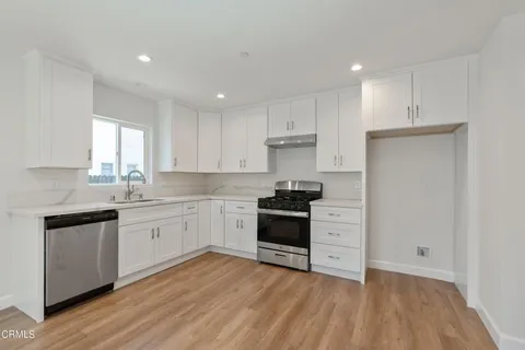a kitchen with granite countertop white cabinets and appliances