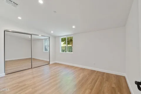 an empty room with wooden floor and door