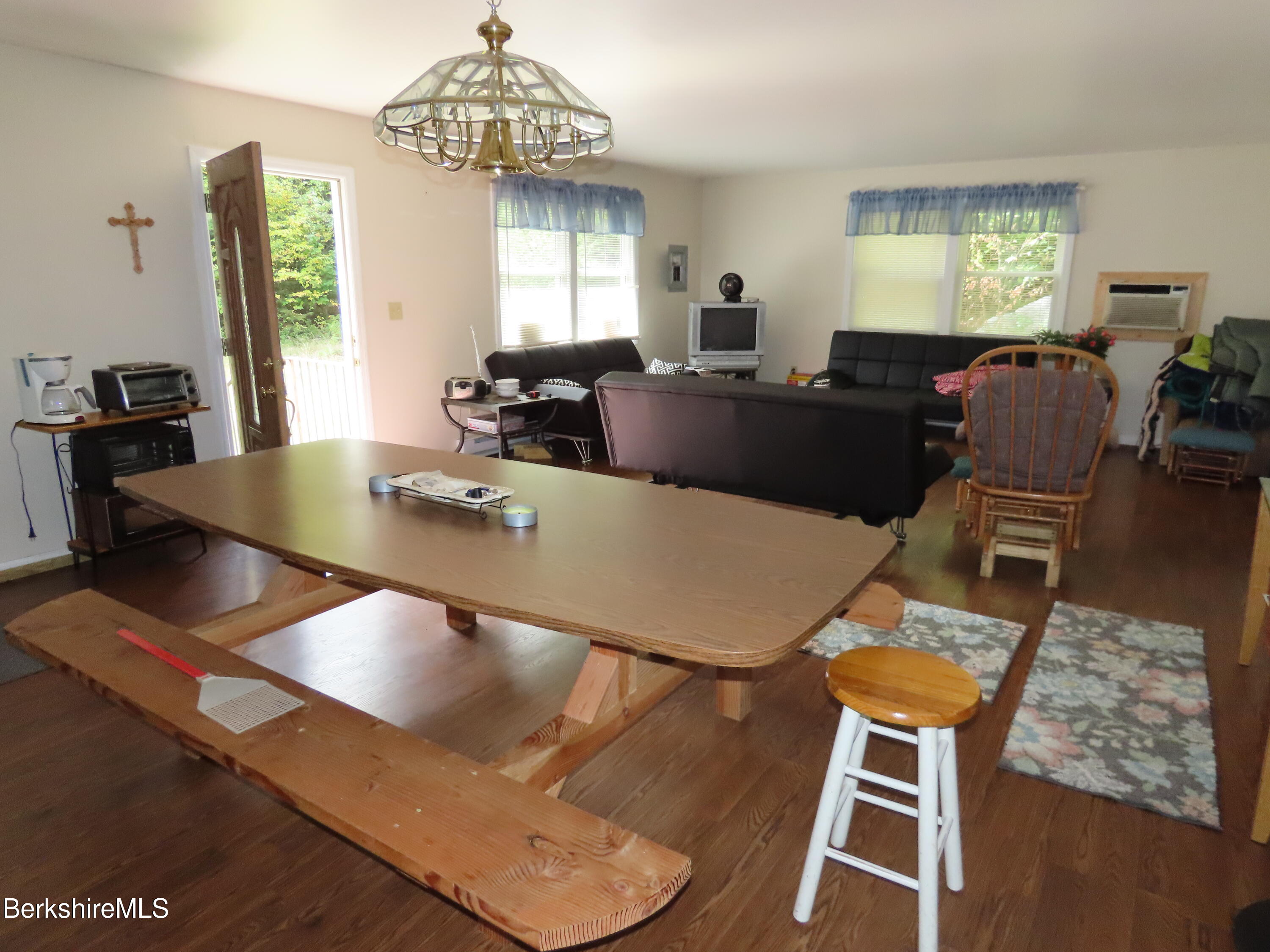 250 Magee Road Stamford, VT 05352 - Photo 10 of 35 a living room with couches chairs and a dining table with wooden floor