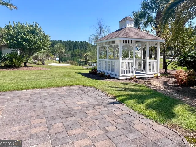 a view of a patio with a table and chairs under an umbrella