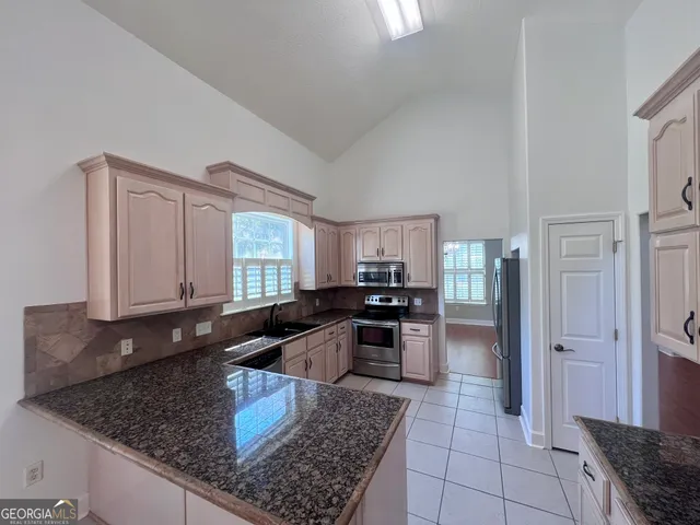 a kitchen with granite countertop a stove and cabinets