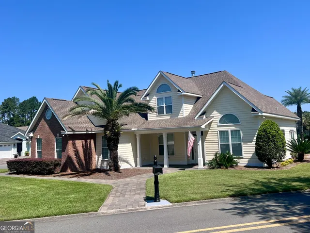 a front view of a house with a garden and yard