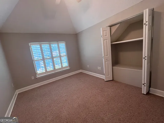 an empty room with windows and closet
