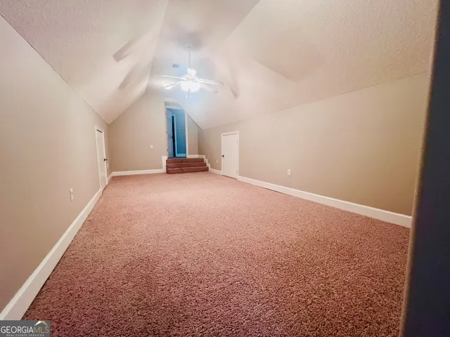 an empty room with a ceiling fan and window