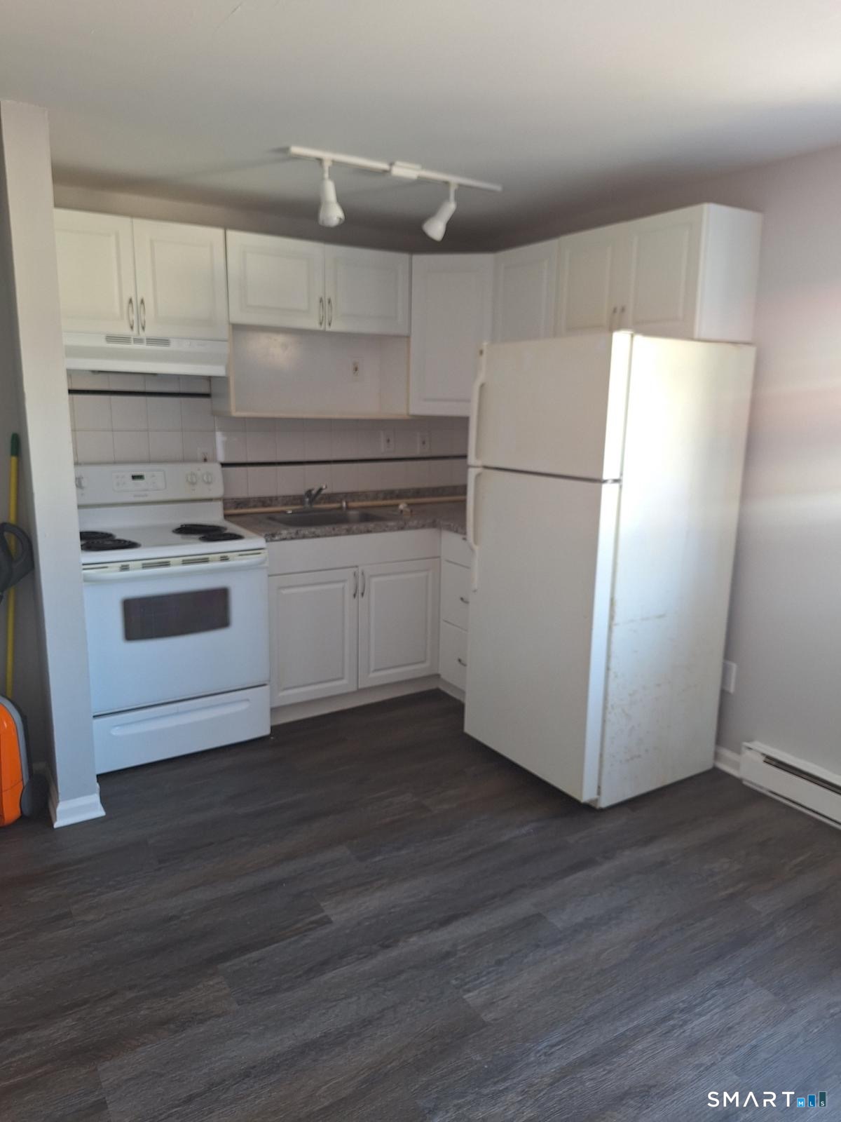 217 Hollister Avenue, Unit A2 Bridgeport, CT 06607 - Photo 1 of 6 a kitchen with granite countertop white cabinets and white appliances