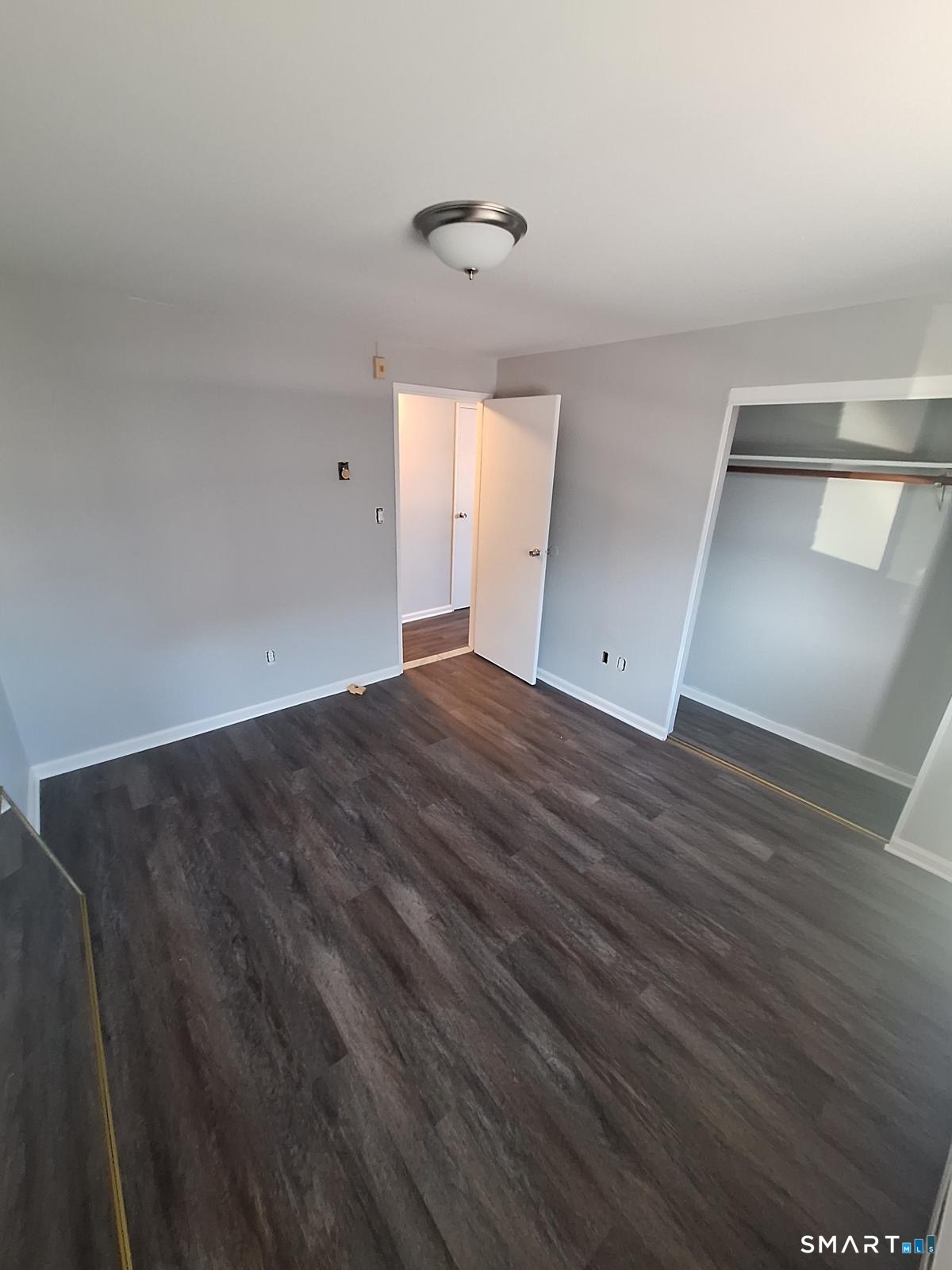217 Hollister Avenue, Unit A2 Bridgeport, CT 06607 - Photo 3 of 6 a view of an empty room with wooden floor and a window