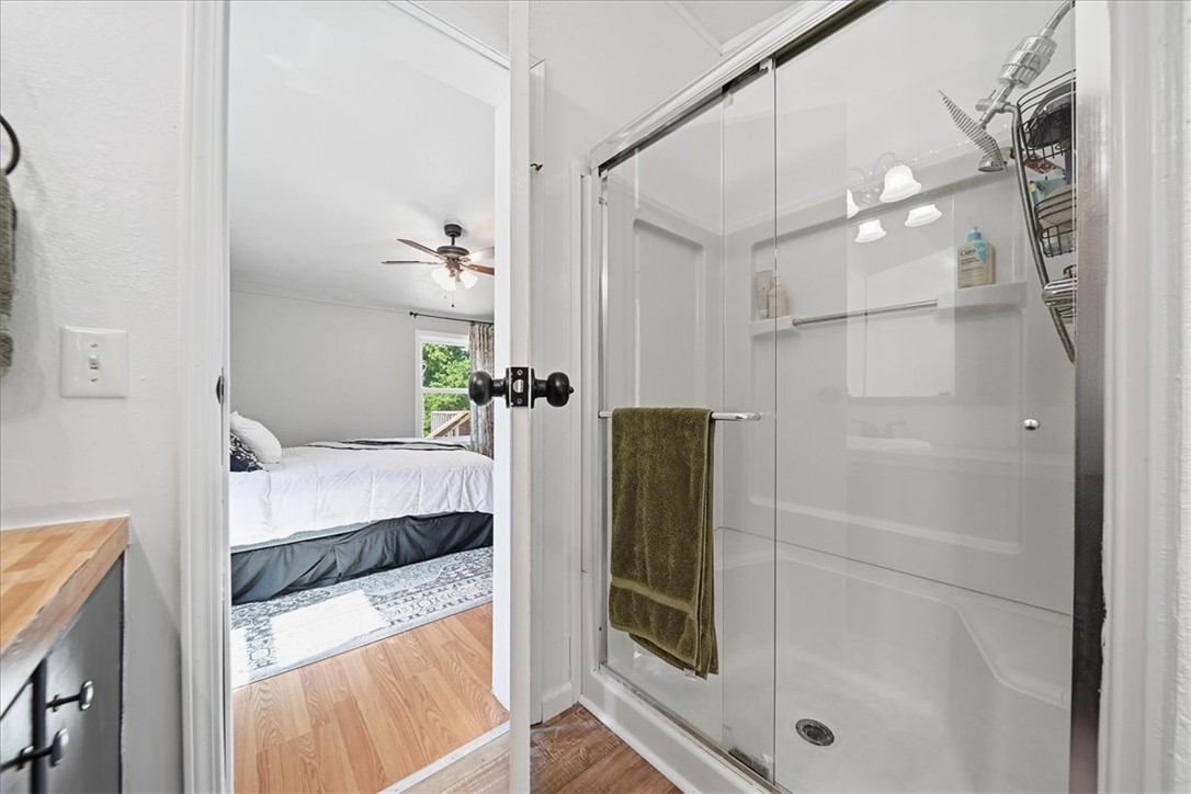 1014 Harris Road Anderson, SC 29625 - Photo 14 of 34 A glimpse into the adjacent bedroom, showcasing the clear glass shower enclosure and bright, easy-care surfaces.