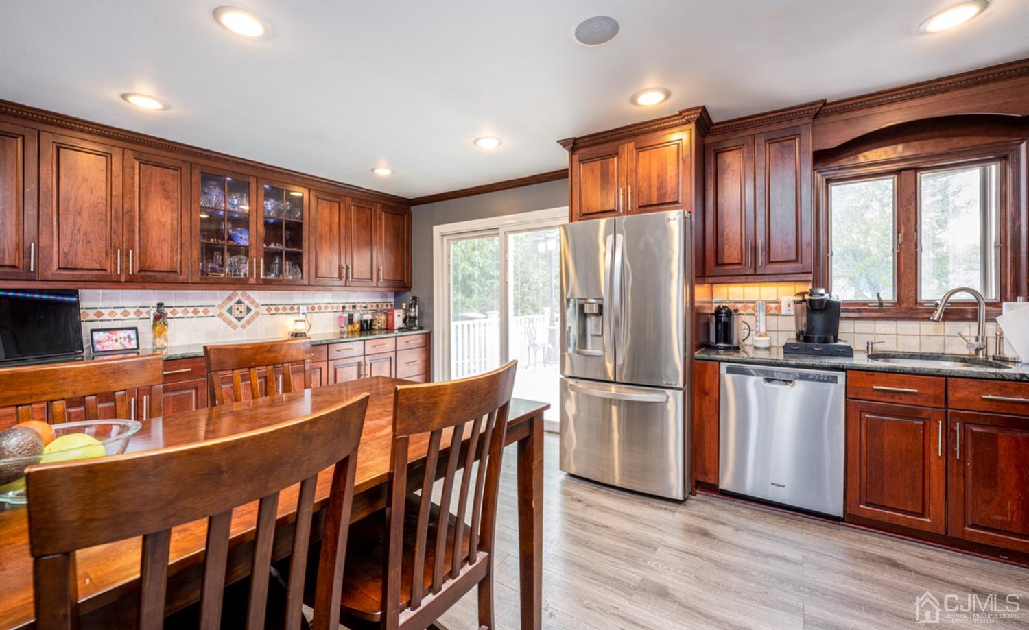 20 Outcalt Road Edison, NJ 08817 - Photo 26 of 35 a kitchen with stainless steel appliances granite countertop a refrigerator a sink dishwasher a stove and white cabinets with wooden floor