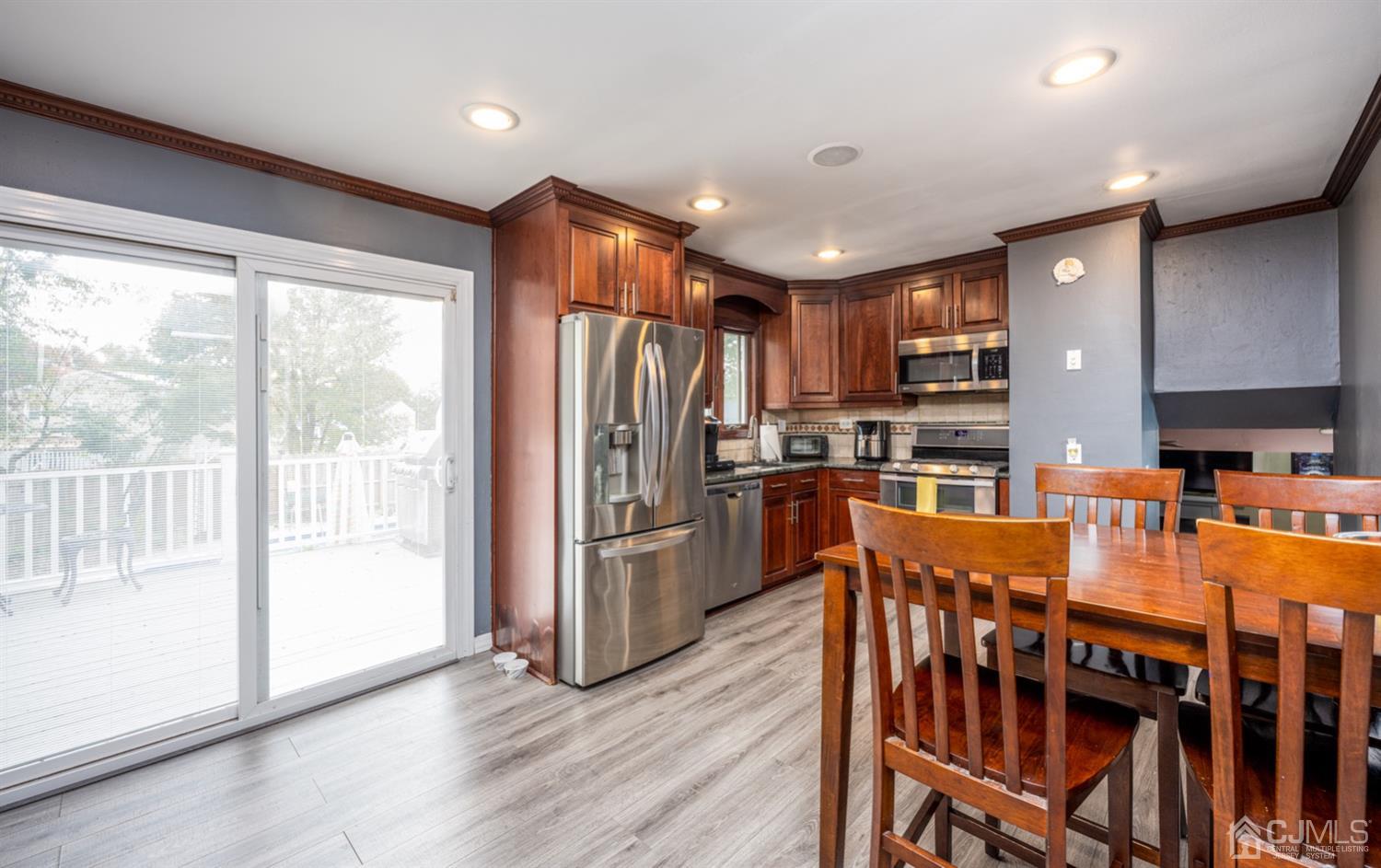 20 Outcalt Road Edison, NJ 08817 - Photo 27 of 35 a kitchen with stainless steel appliances granite countertop a refrigerator a stove top oven and a dining table with wooden floor