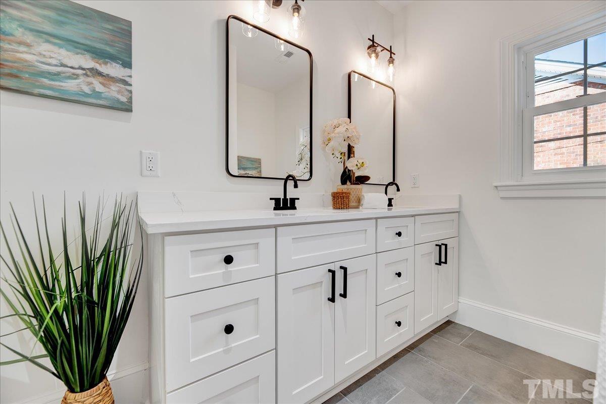 602 West Main Street Benson, NC 27504 - Photo 19 of 42 a bathroom with double vanity sink a mirror and window