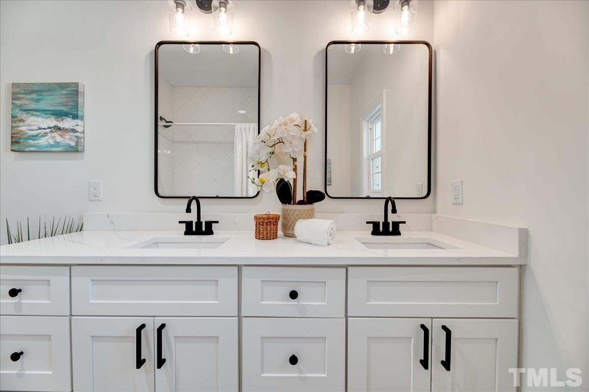 602 West Main Street Benson, NC 27504 - Photo 20 of 42 a bathroom with double vanity sinks and a mirror