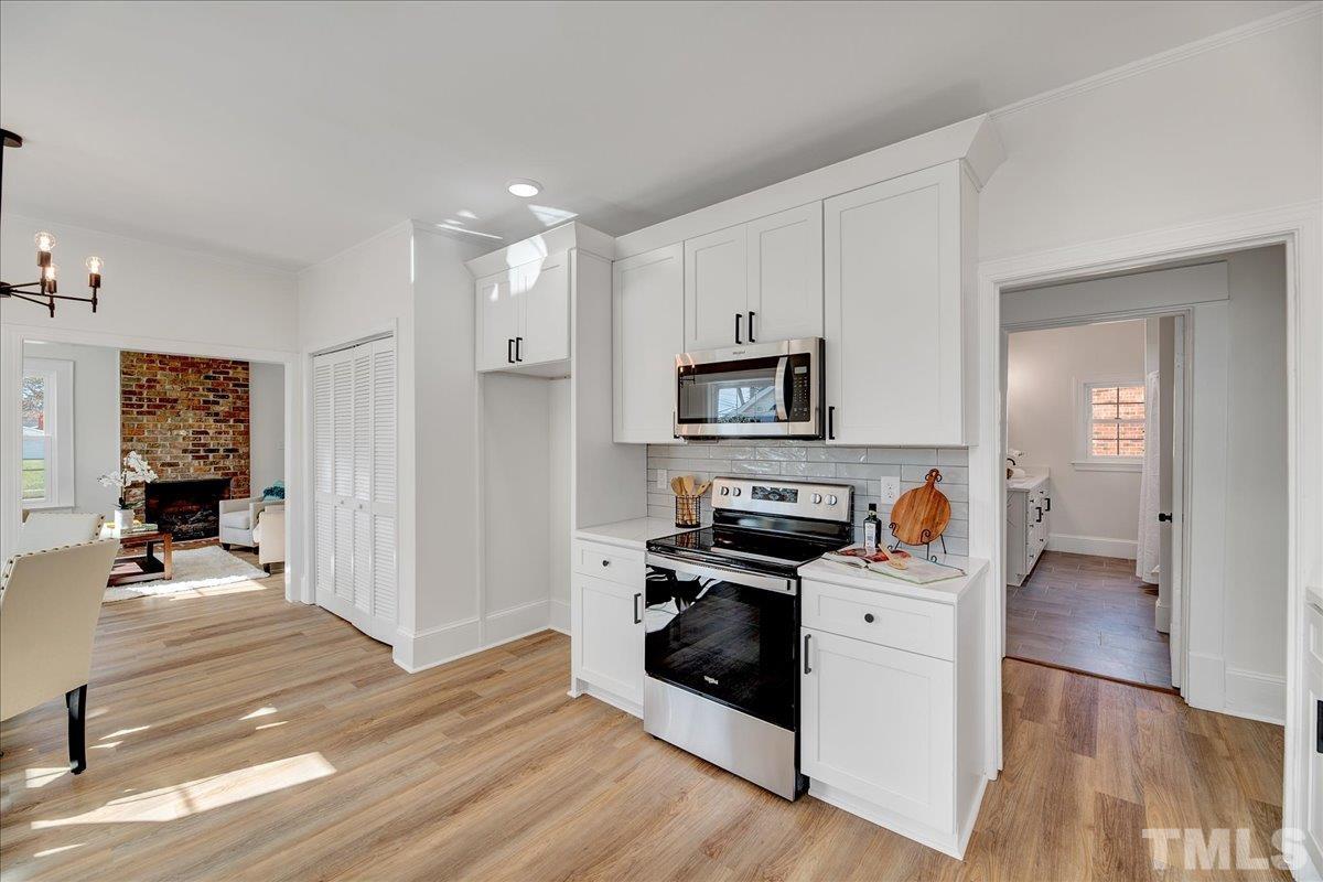 602 West Main Street Benson, NC 27504 - Photo 10 of 42 a kitchen with white cabinets and black appliances