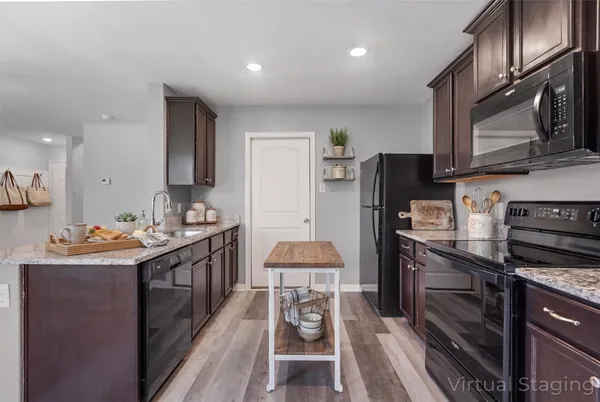 a kitchen with stainless steel appliances granite countertop a refrigerator a stove and a sink