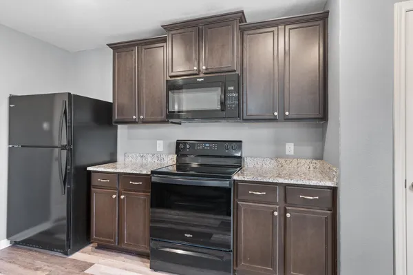 a kitchen with stainless steel appliances granite countertop a stove refrigerator and a sink