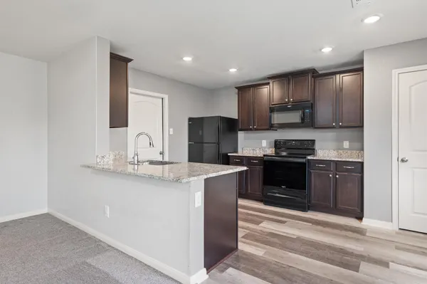 a kitchen with kitchen island granite countertop cabinets and stainless steel appliances