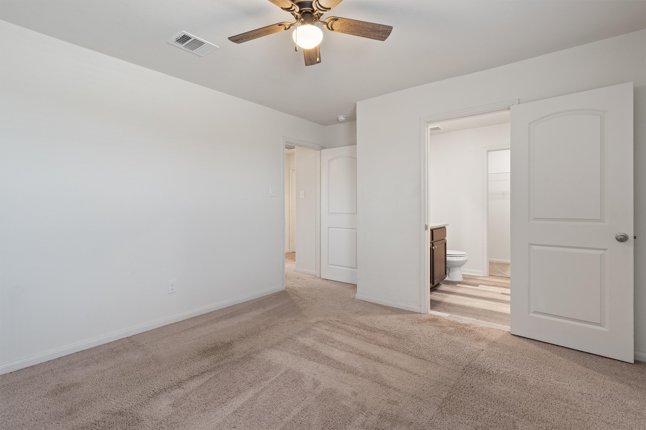 163 Niven Path, Unit 12K Jarrell, TX 76537 - Photo 15 of 39 The Primary bedroom has lots of space and an attached bathroom with wood look vinyl flooring and a walk in closet.
