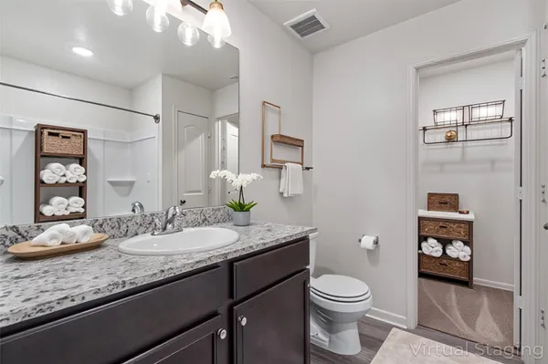 a bathroom with a granite countertop sink toilet and shower