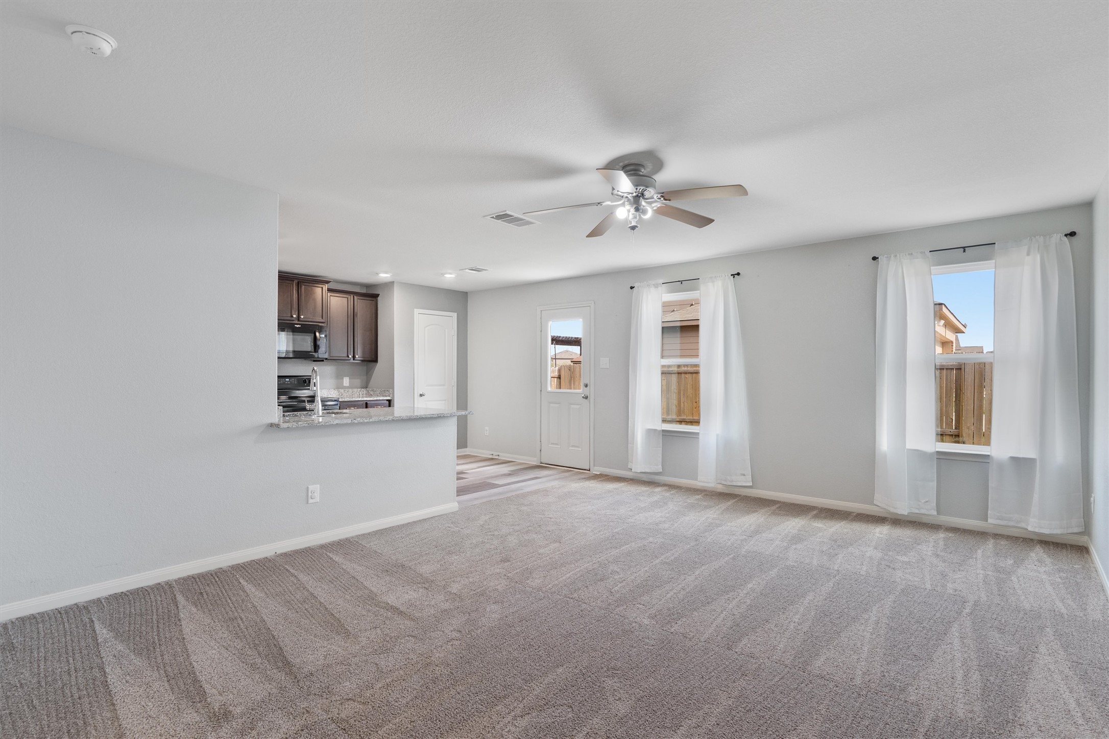 163 Niven Path, Unit 12K Jarrell, TX 76537 - Photo 2 of 39 Nice sized Living Room with lots of natural lighting. Open to the kitchen. Recent carpeting.