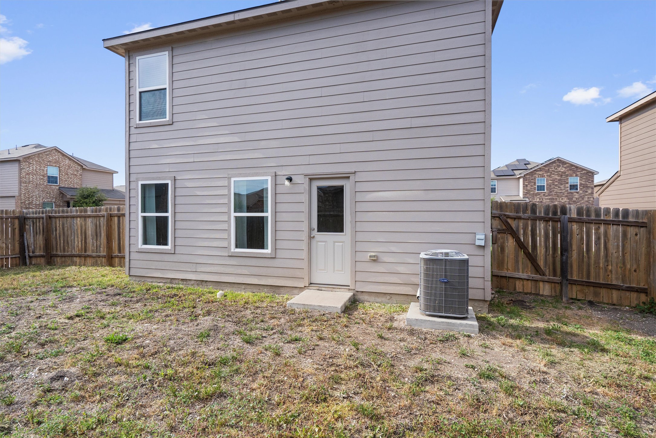 163 Niven Path, Unit 12K Jarrell, TX 76537 - Photo 32 of 39 Rear view of property featuring a fenced backyard.