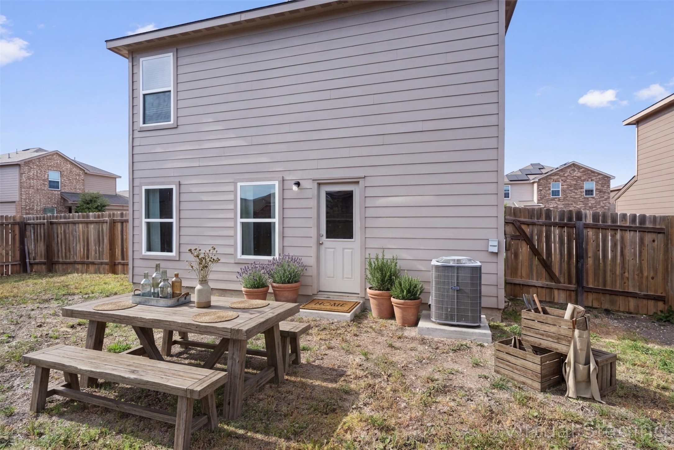163 Niven Path, Unit 12K Jarrell, TX 76537 - Photo 33 of 39 Back of house featuring a fenced backyard, a patio, and outdoor dining space. VIRTUALLY STAGED