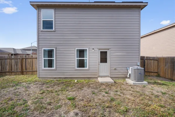 a view of a house with a yard and wooden fence