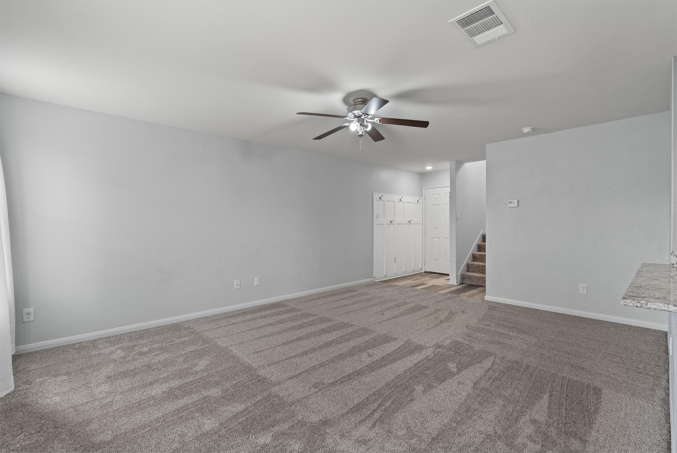 163 Niven Path, Unit 12K Jarrell, TX 76537 - Photo 6 of 39 View of the Living Room from the Kitchen. The entry from the Garage has a wooden wall to hang bookbags and coats. Vinyl flooring at the entry to protect the carpet.